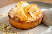 Freshly baked apple pie with a crunchy crumb topping and caramelized pieces of fruit on top. The apples’ bright, golden hues