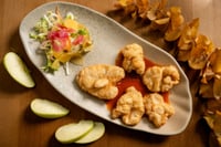 Plato de kokotxas de bacalao en MATRICE Restaurante, servido sobre una sartén de barro con rodajas de manzana, zanahoria y